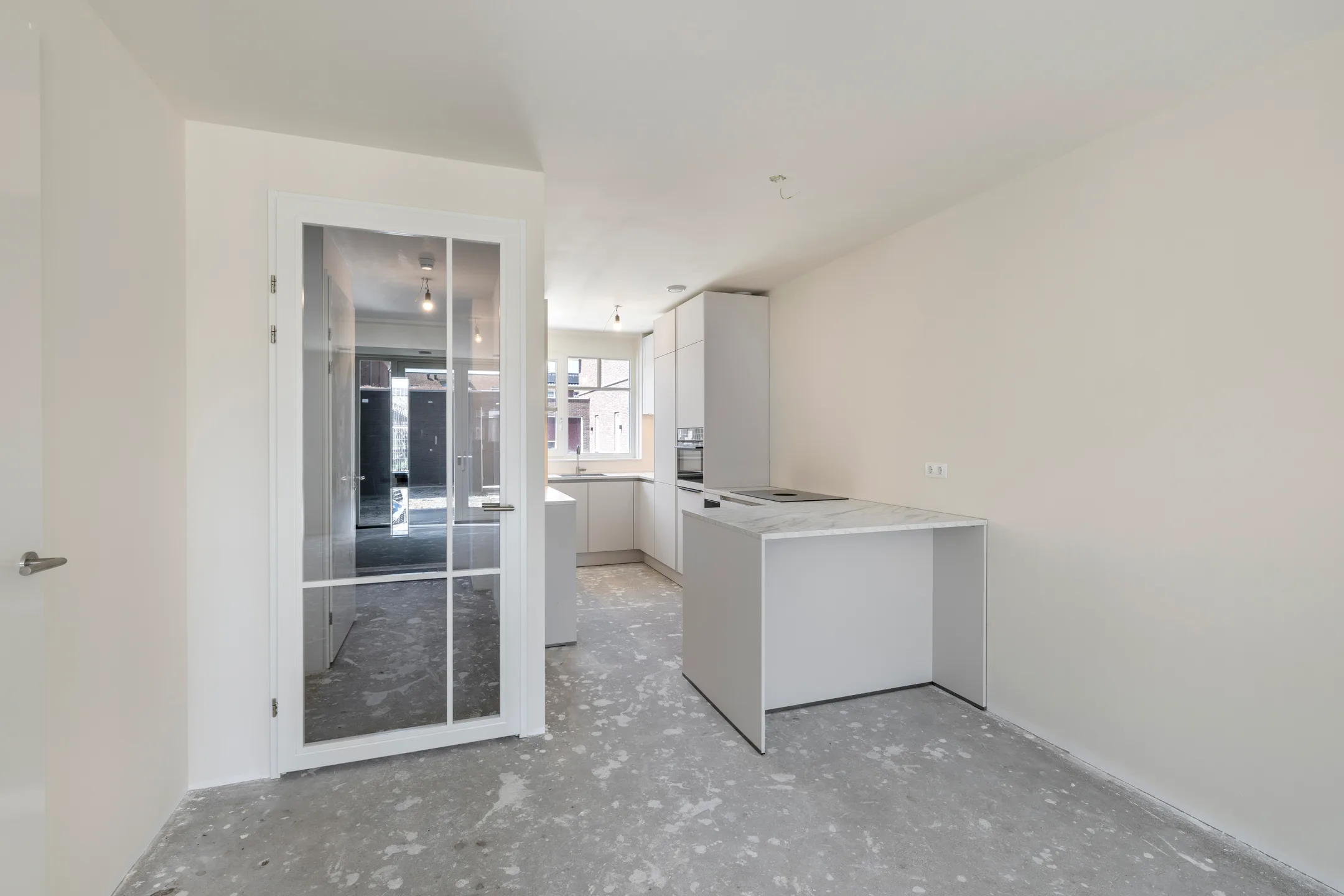Lege woonkamer met open keukenblok in een net opgeleverd appartement