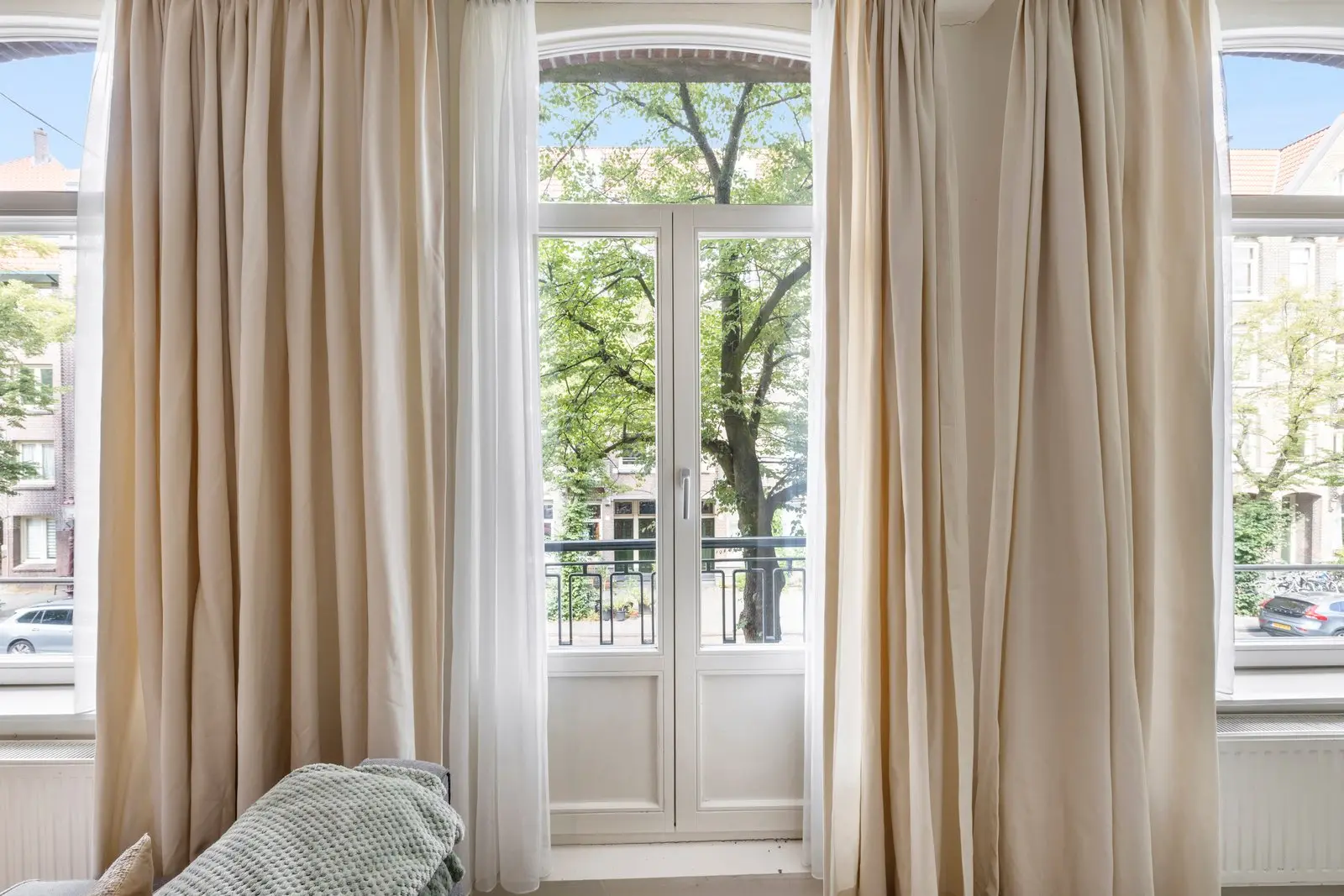 Openslaande deuren naar het balkon, met een boom vlak ervoor