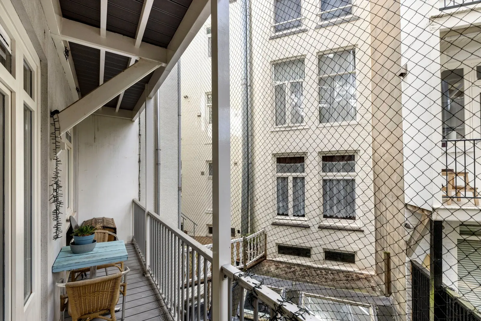 Achterbalkon met gaas en de achtergevels erachter
