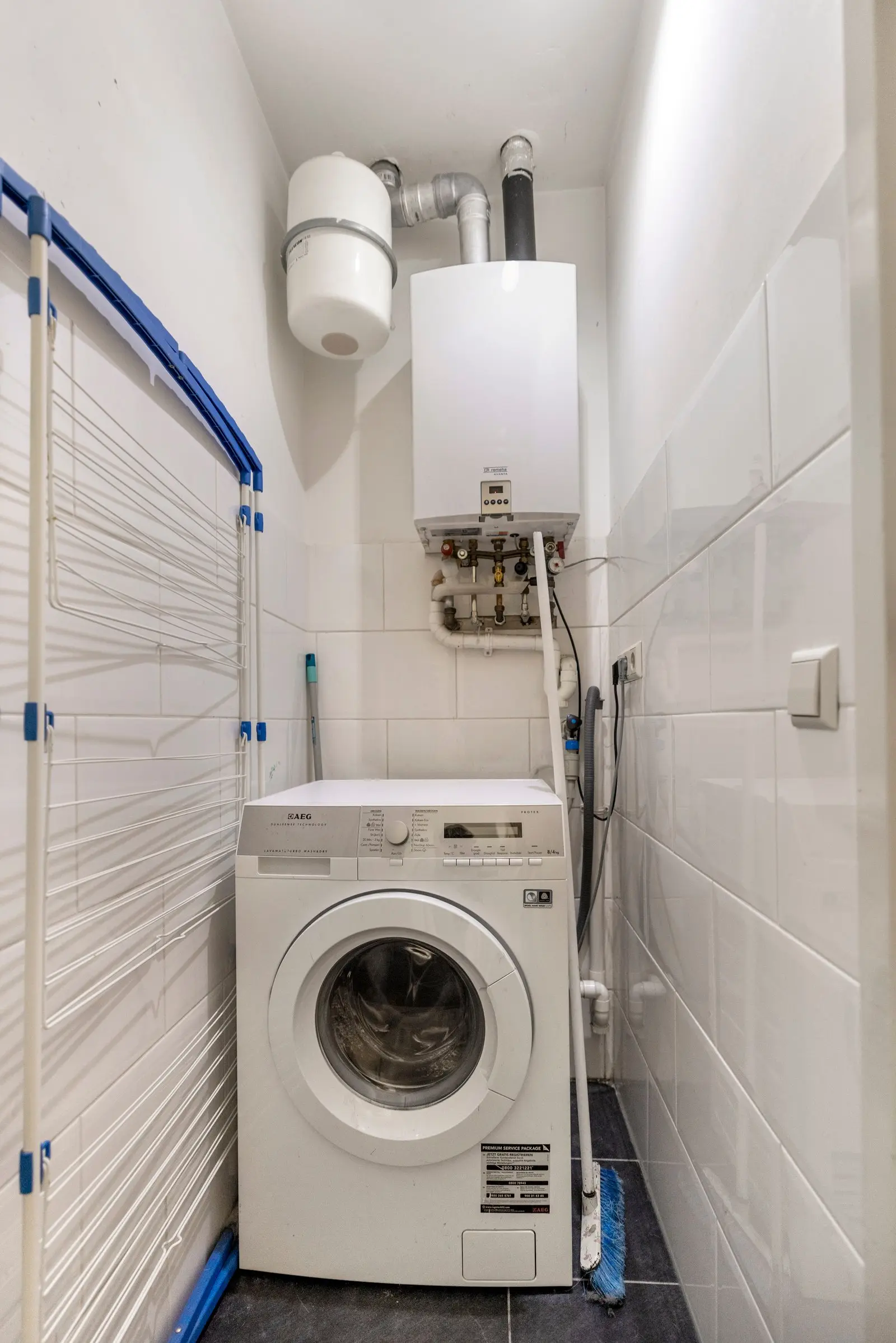 Wasruimte met wasmachine en boiler