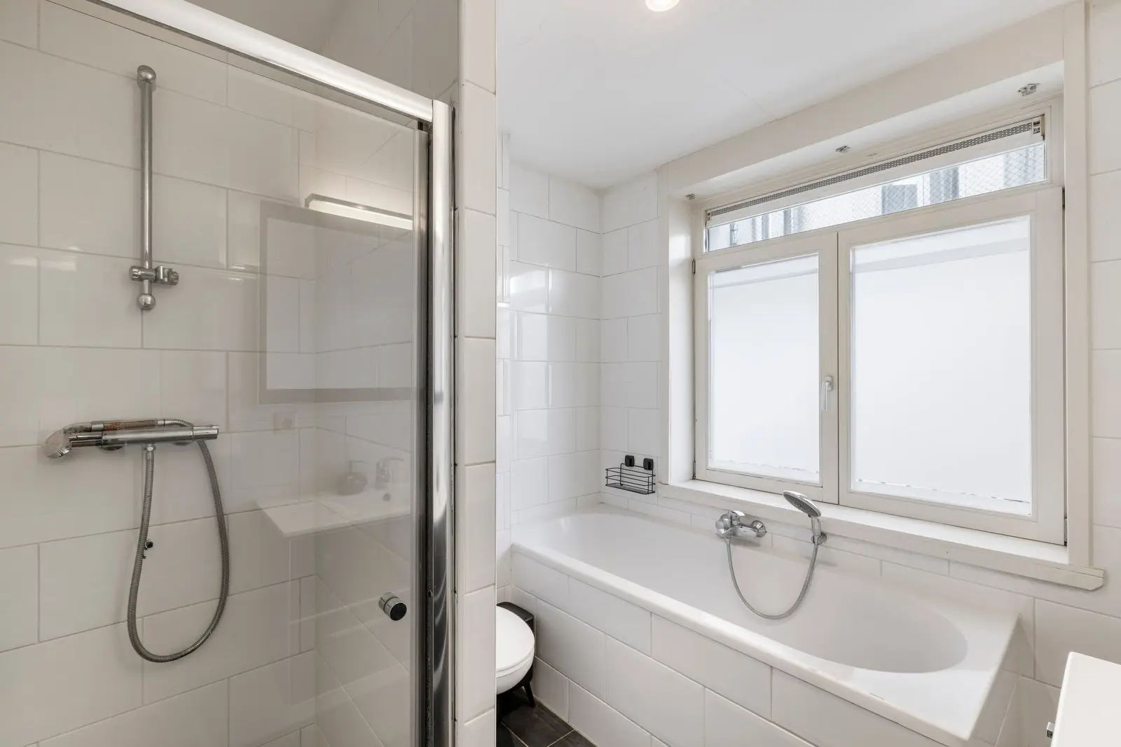 Badkamer met ligbad en douche