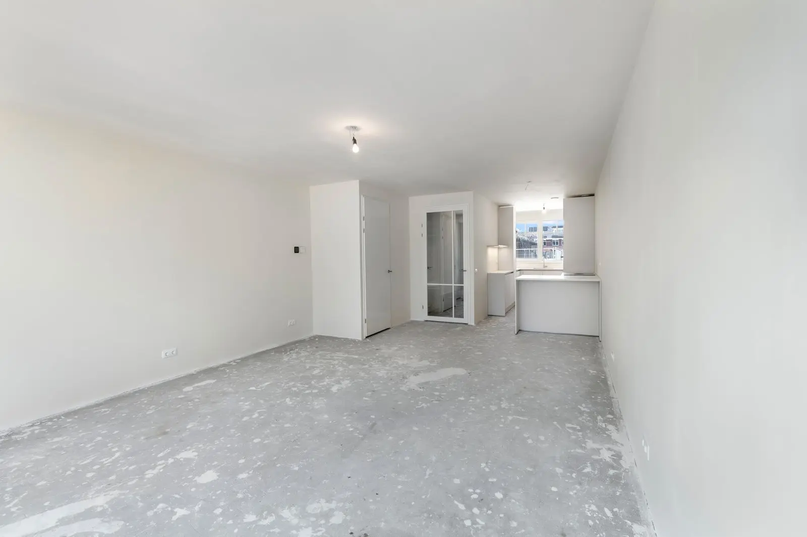 Lege woonkamer met de trap en de doorgang naar de keuken