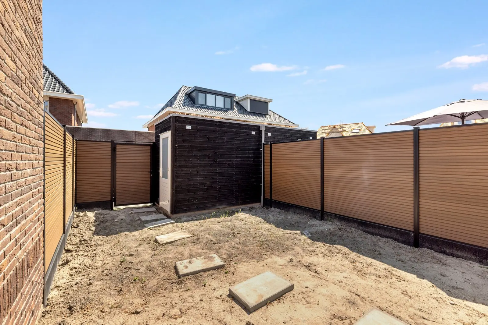 Achtertuin met schutting en de berging