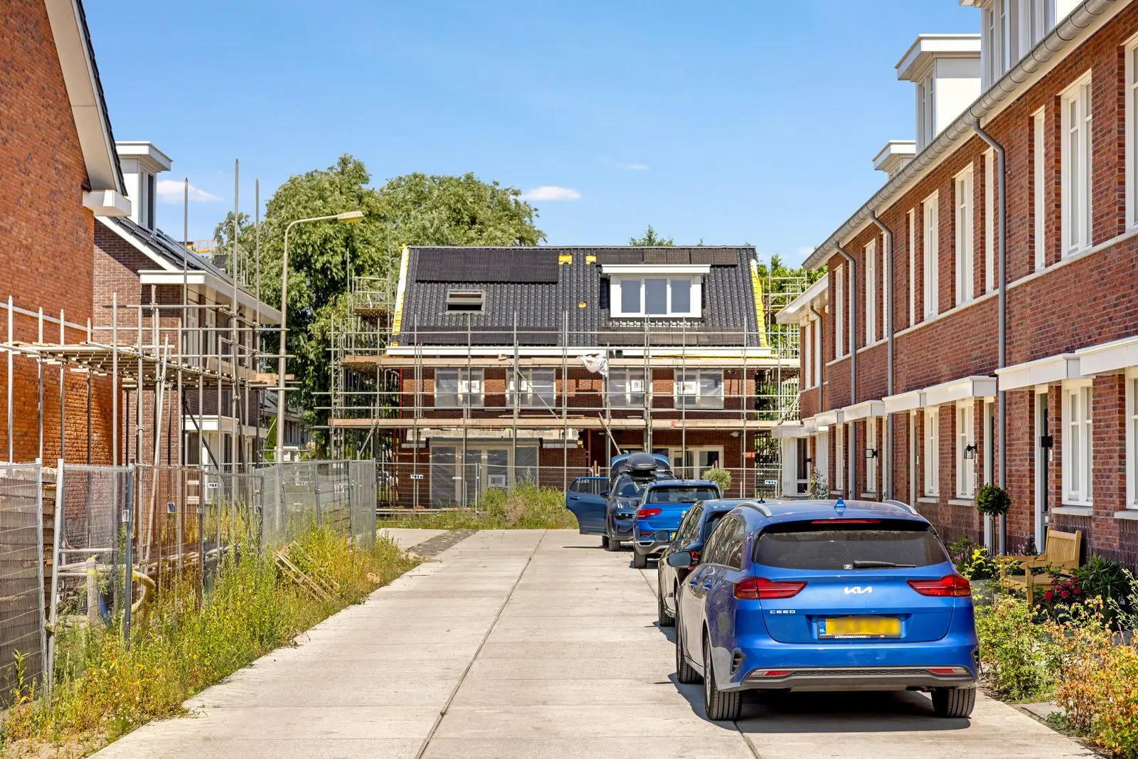 De straat met woningen in aanbouw en steigers