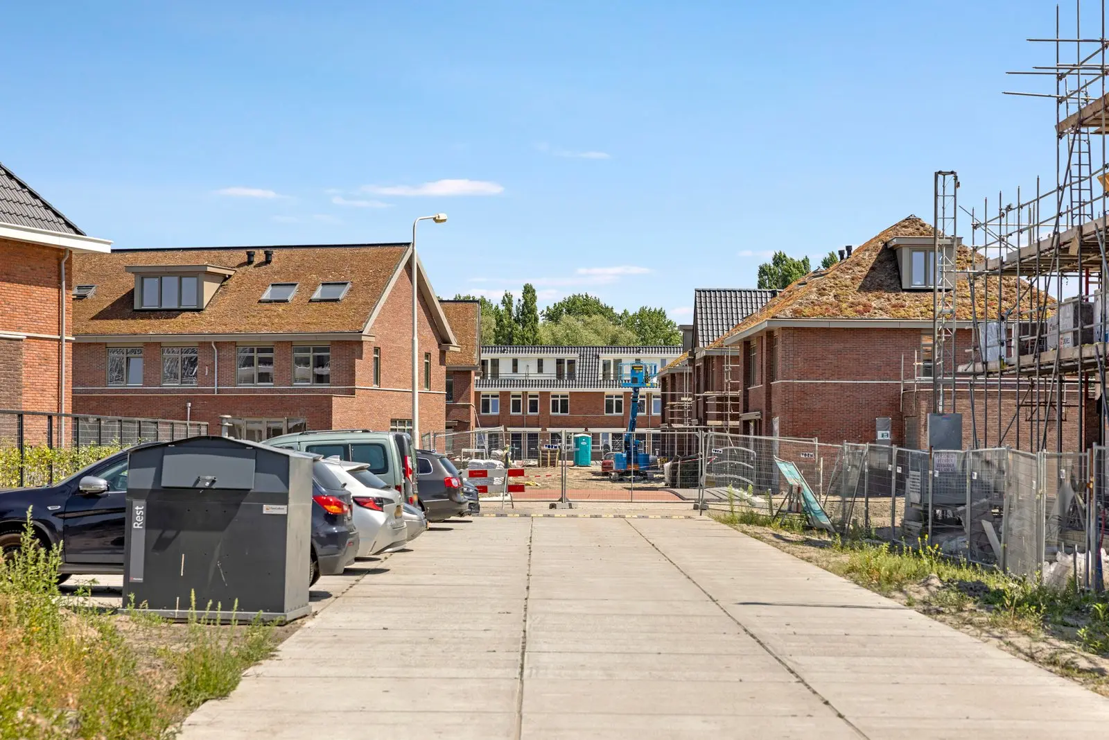De straat met parkeerplaatsen en nieuwbouw
