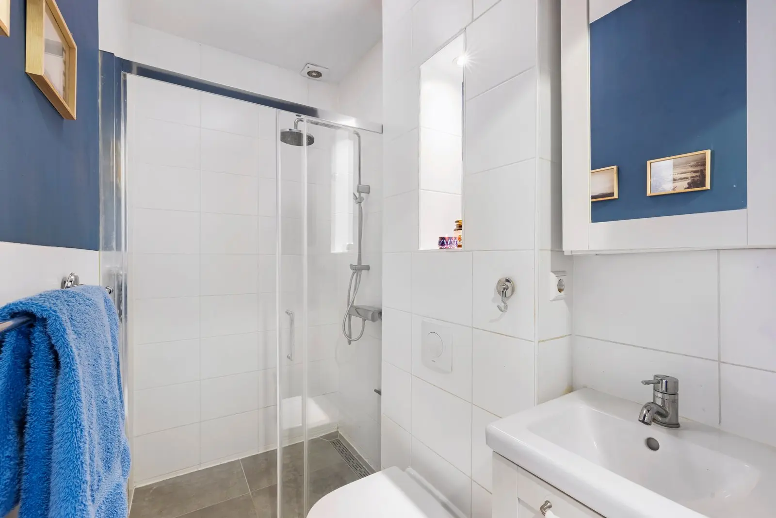 Badkamer met douchecabine en wastafel