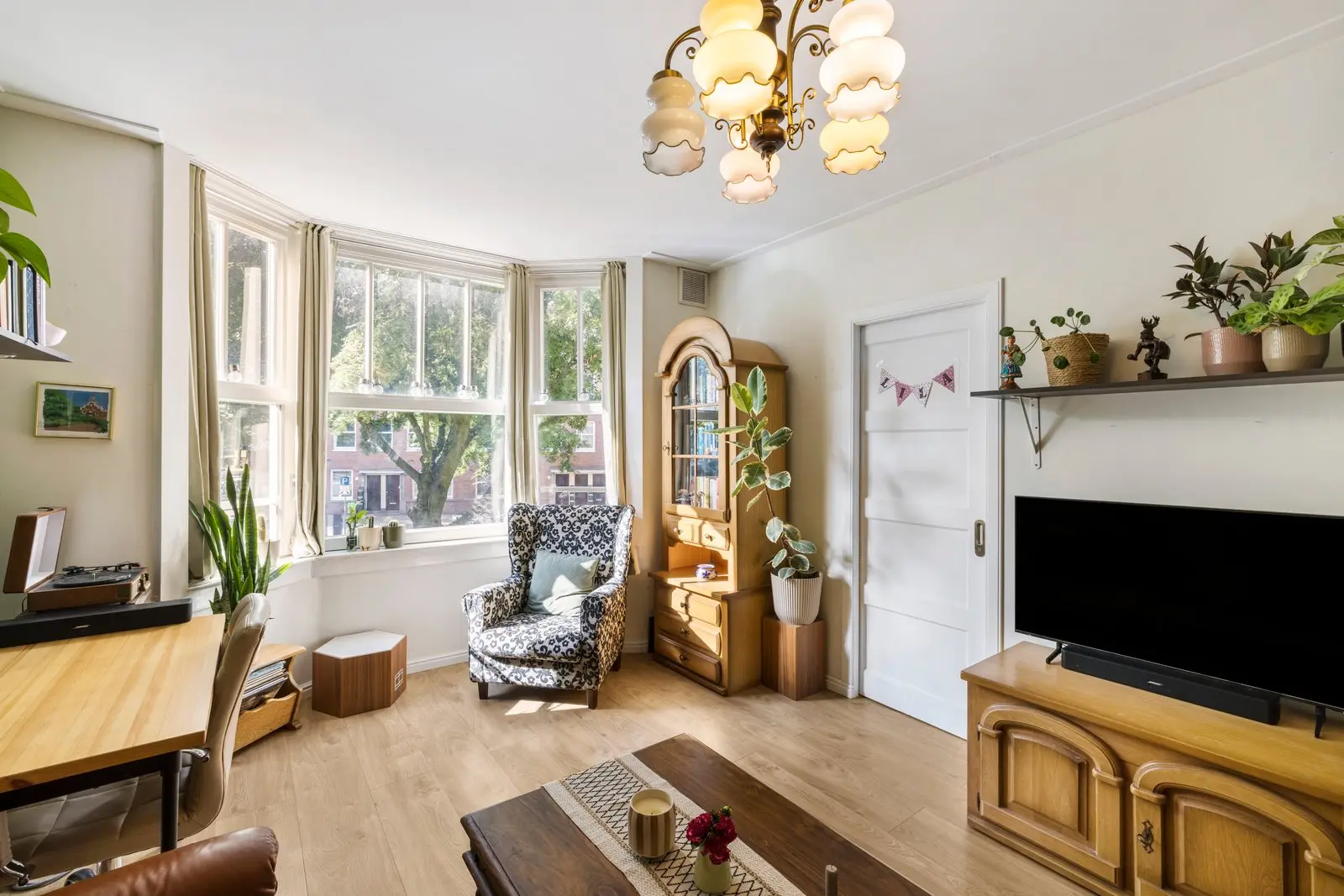 Woonkamer met erker en een kast met glas-in-lood