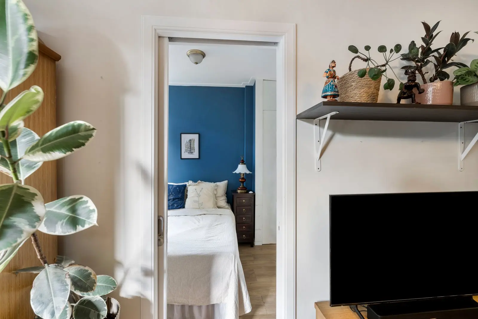 Doorkijk naar de slaapkamer met diepblauwe wand
