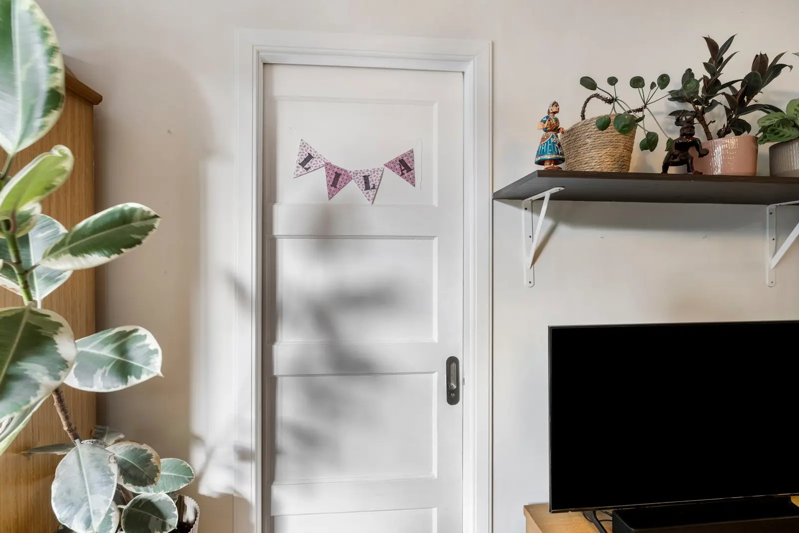 Deur naar de slaapkamer, met vlaggetjes en een wandplank
