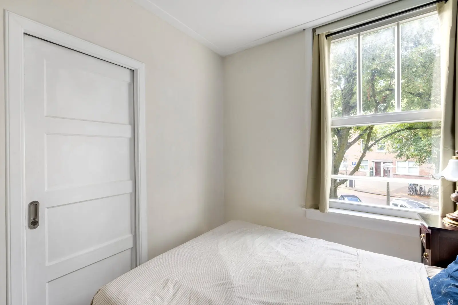 Lichte slaapkamer met het bed onder het raam