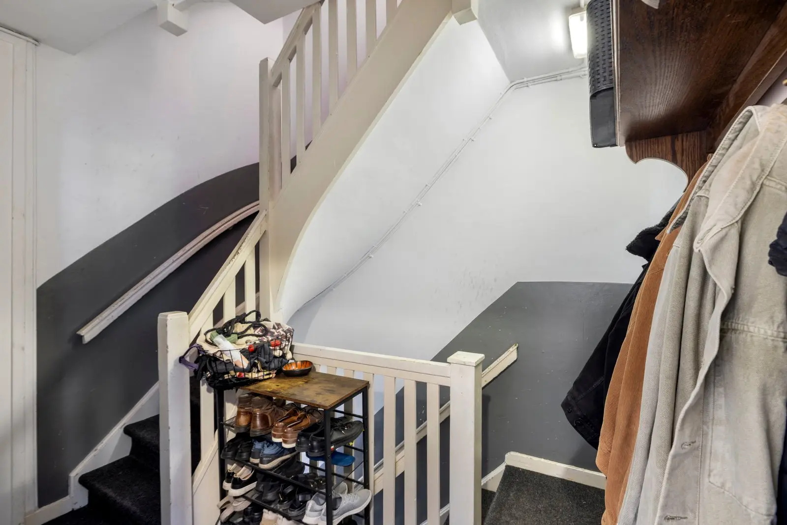 Overloop met trap en een schoenenrek