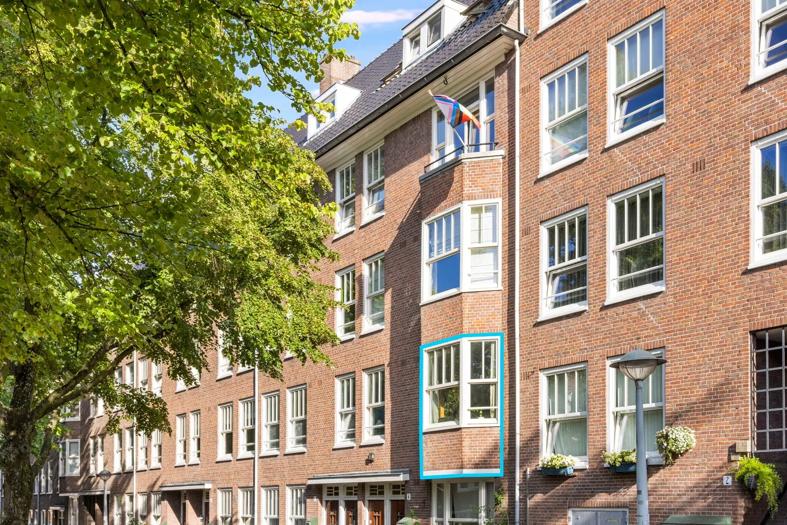 De gevel met witte kozijnen, gezien vanaf de overkant
