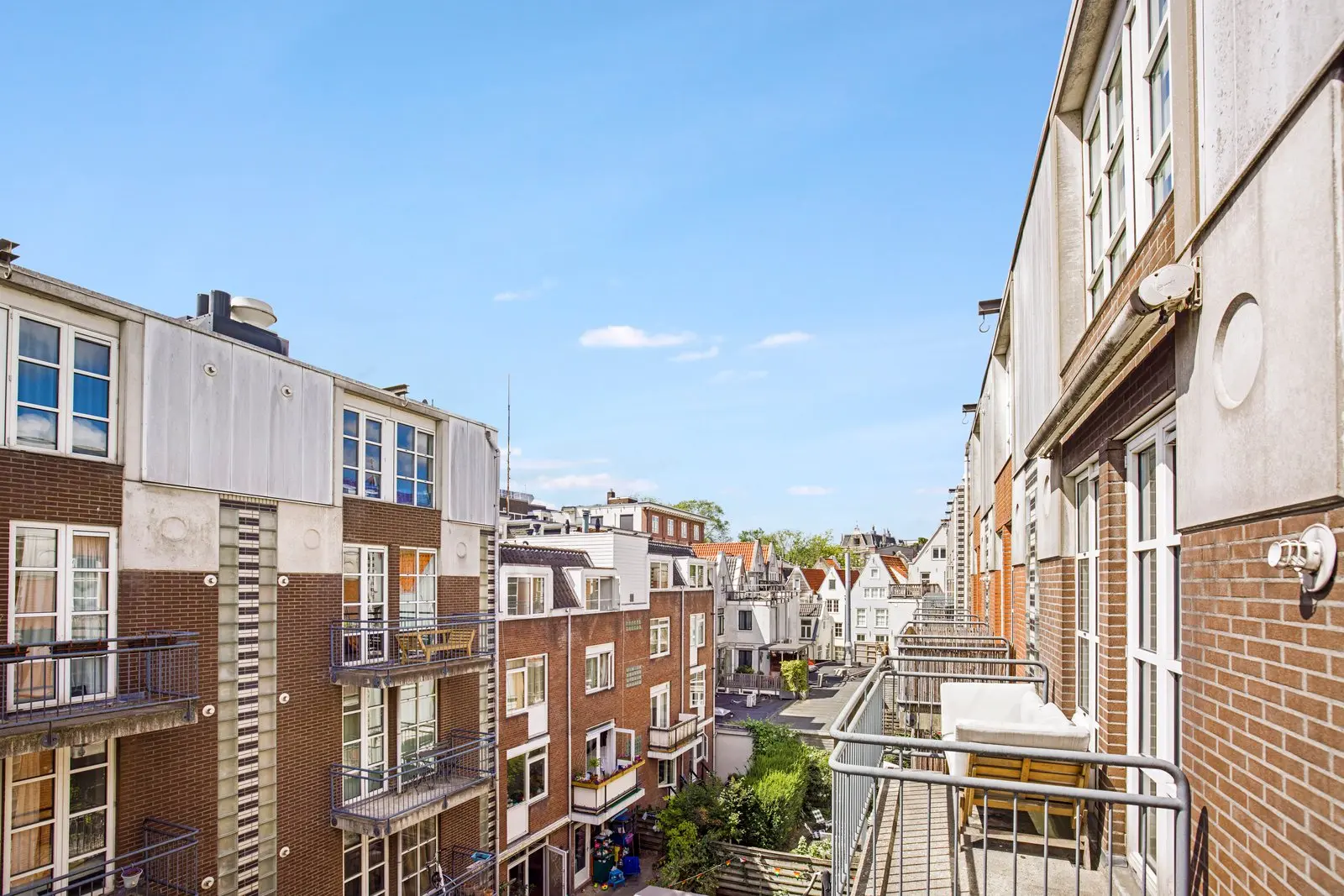 Vanaf het balkon zicht over de balkons van de omliggende gebouwen, met puntgevels in de verte