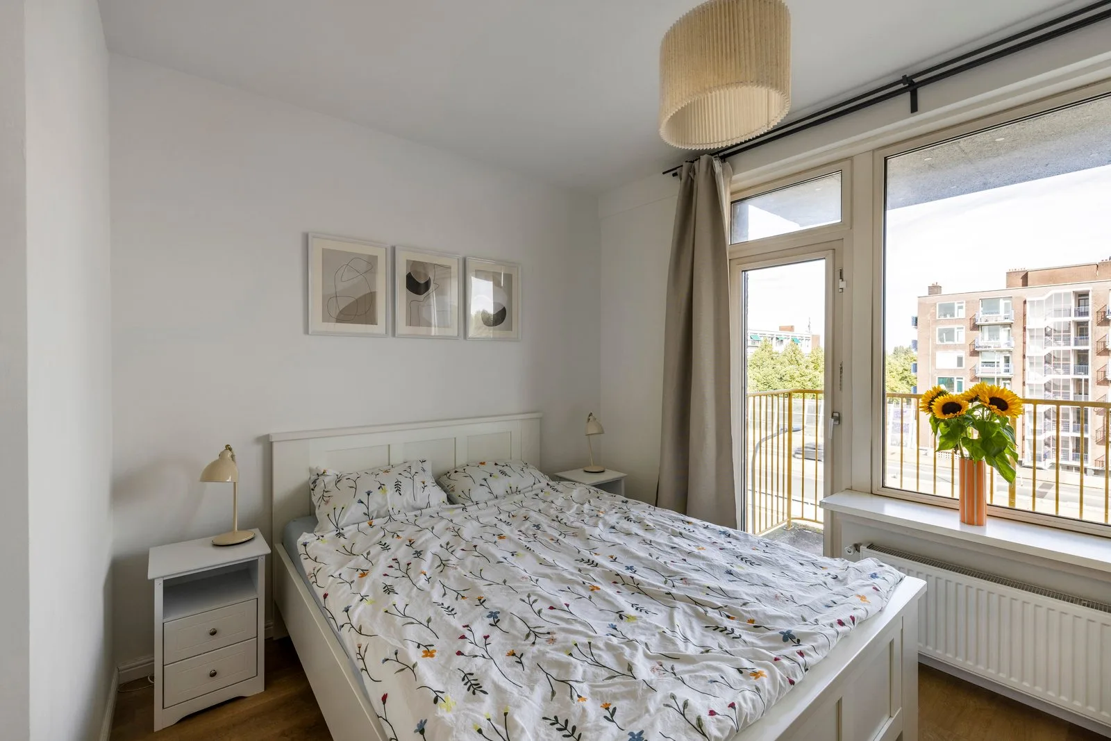 Tweepersoonsbed tussen de nachtkastjes, rechts de balkondeur naast het raam
