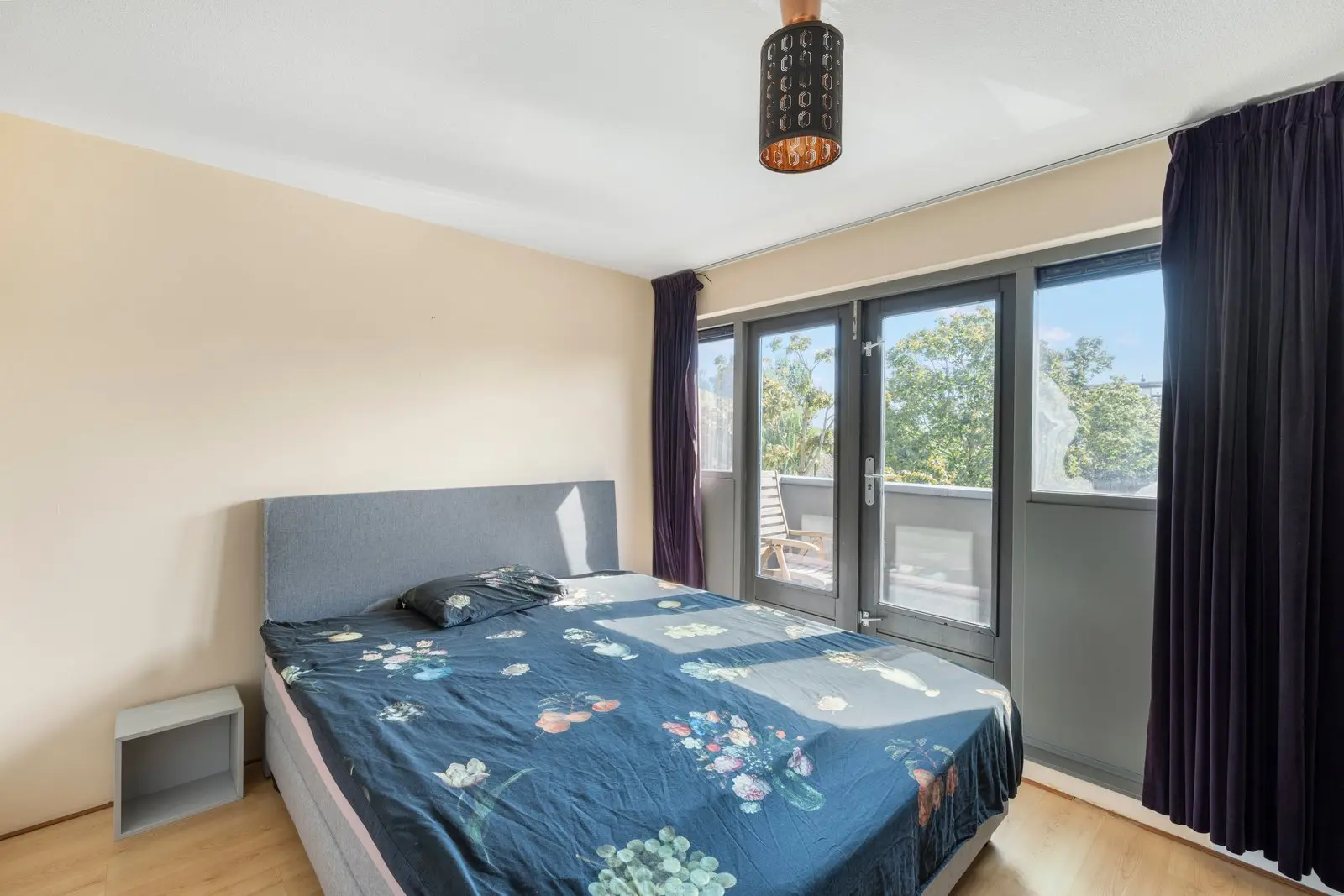 Slaapkamer met tweepersoonsbed en openslaande deuren
