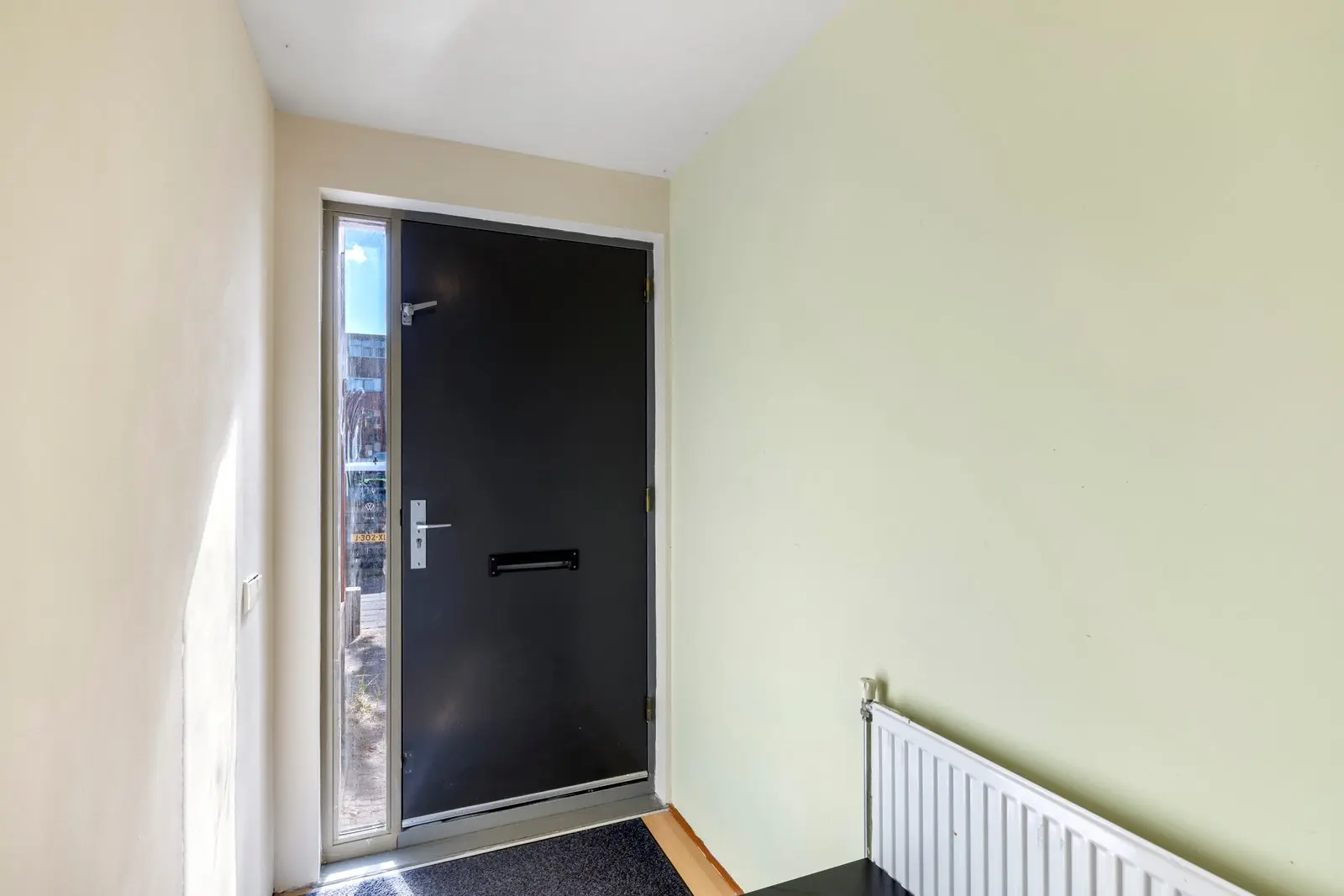Entree met de voordeur en de radiator