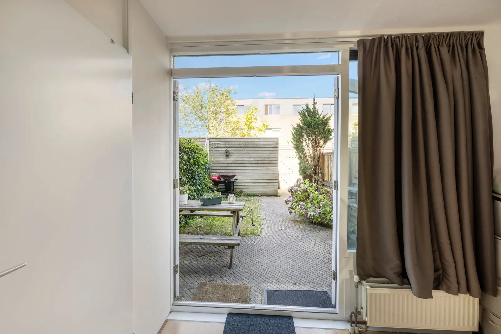 Open tuindeur met zicht op het terras