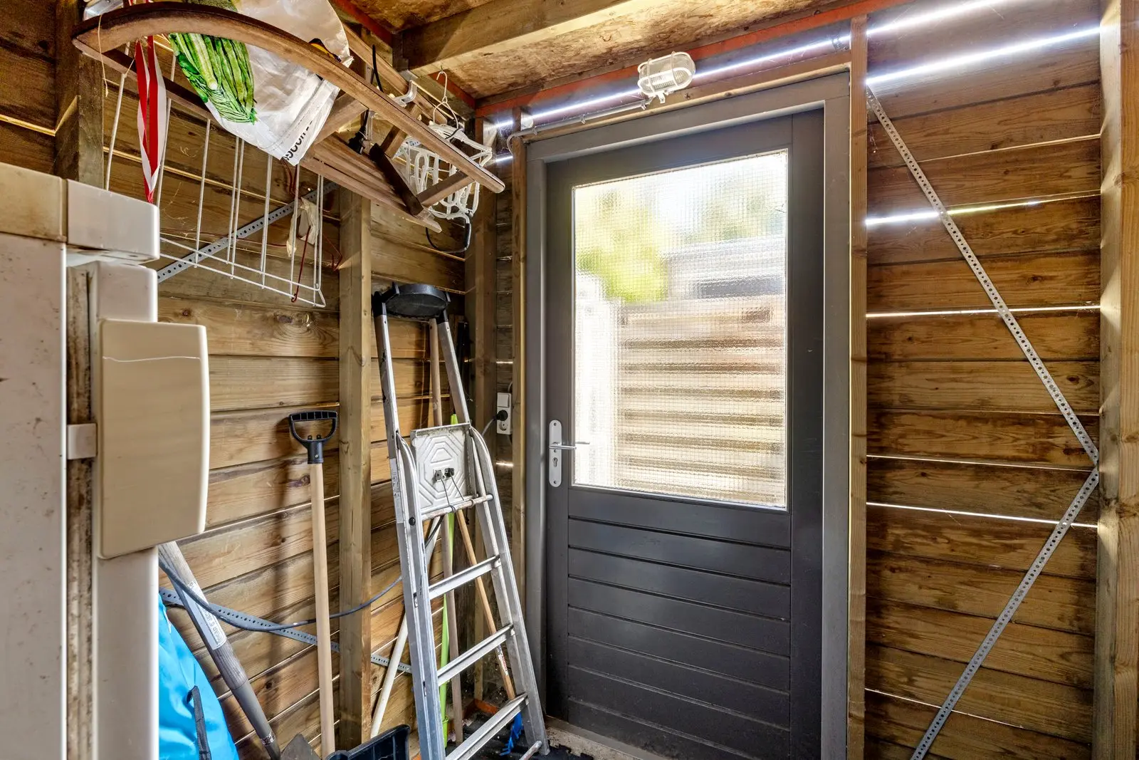 De berging van binnen, met de deur naar de tuin