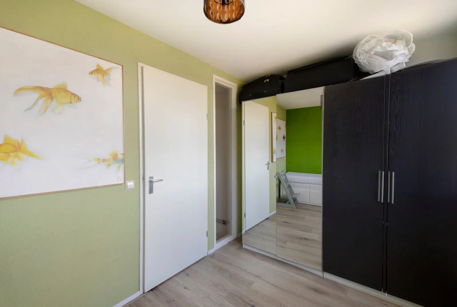Kamer met groene wand en de doorgang naar de overloop