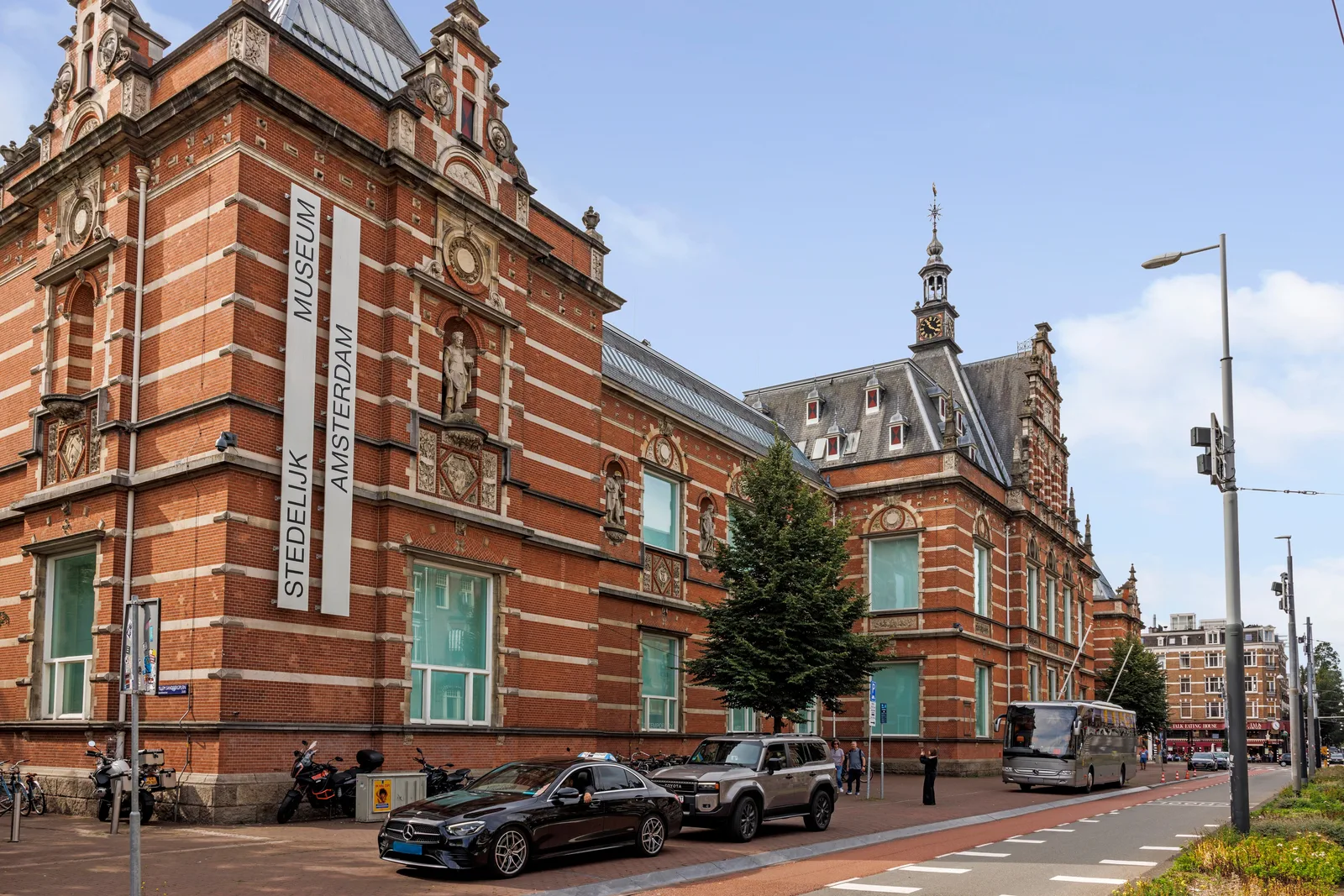 Rode baksteen met witte speklagen en beelden in nissen, het oude Stedelijk Museum