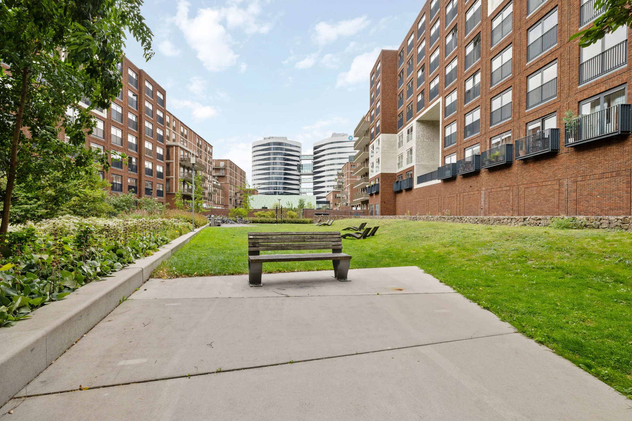 Bankje op het binnenterrein, met kantoorgebouwen in de verte